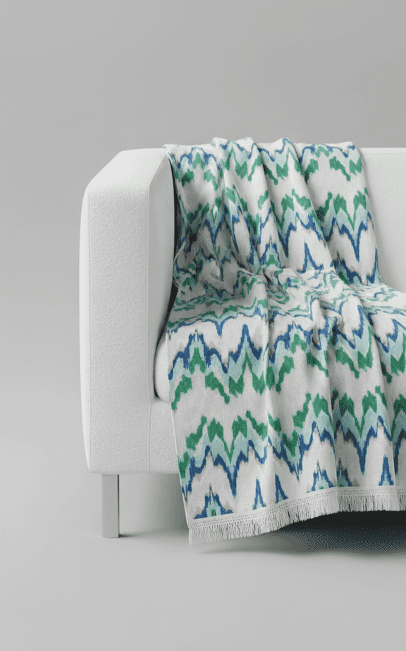 Jeté surdimensionné à motif ikat bleu et vert avec bordure à franges sur canapé blanc